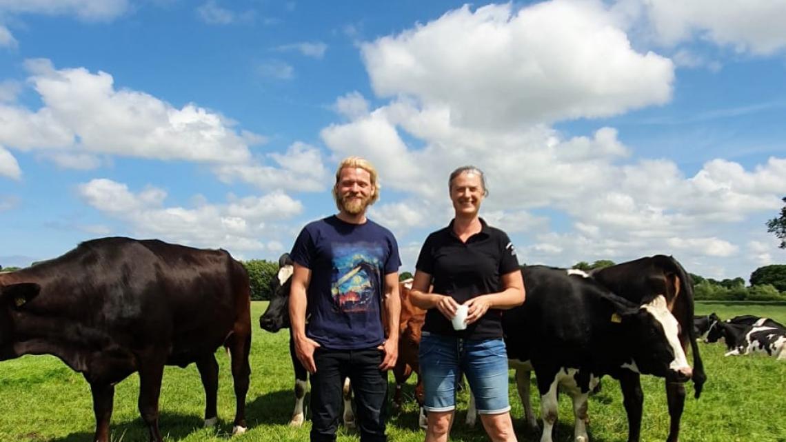 Dennys Bornhöft und Mirja Prall bei den Milchkühen auf der Wiese. 